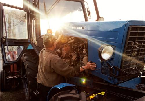 Tractor being fixed by farmer